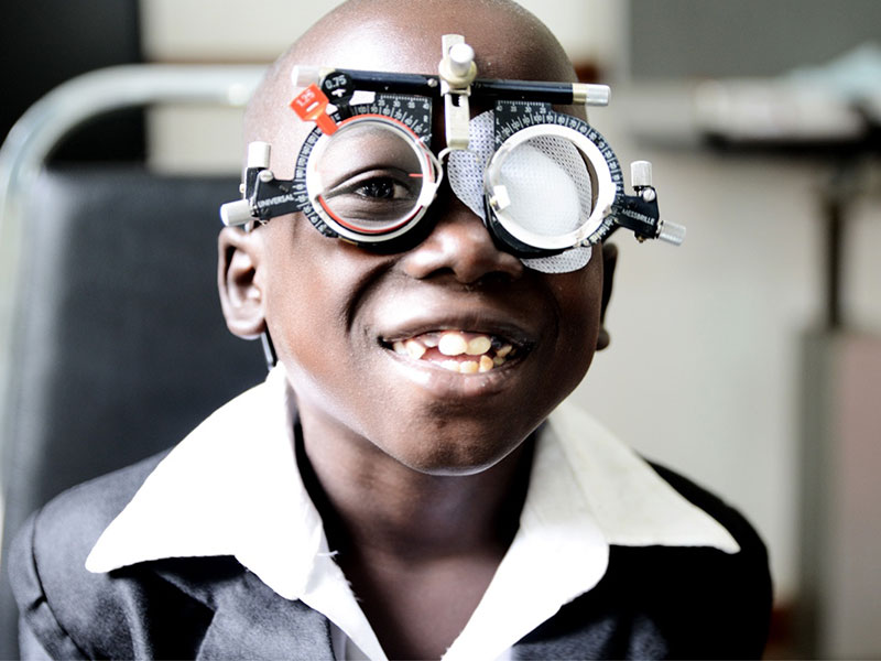 Kleiner Junge der eine Messbrille trägt, zur Feststellung der Sehstärke