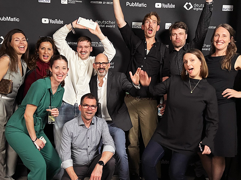 10 Personen aus dem IBM iX Team jubeln und celebrieren den Deutschen Digital Award 2022