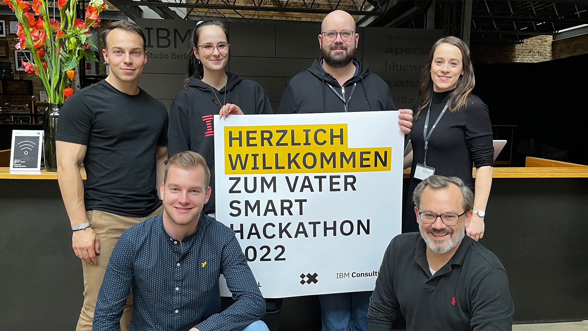 Picture of the Berlin team holding a welcome poster