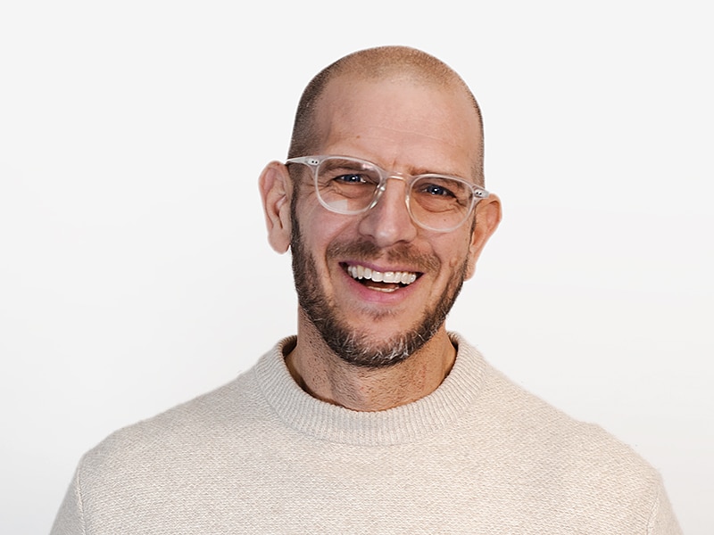 Man in glasses smiling broadly.