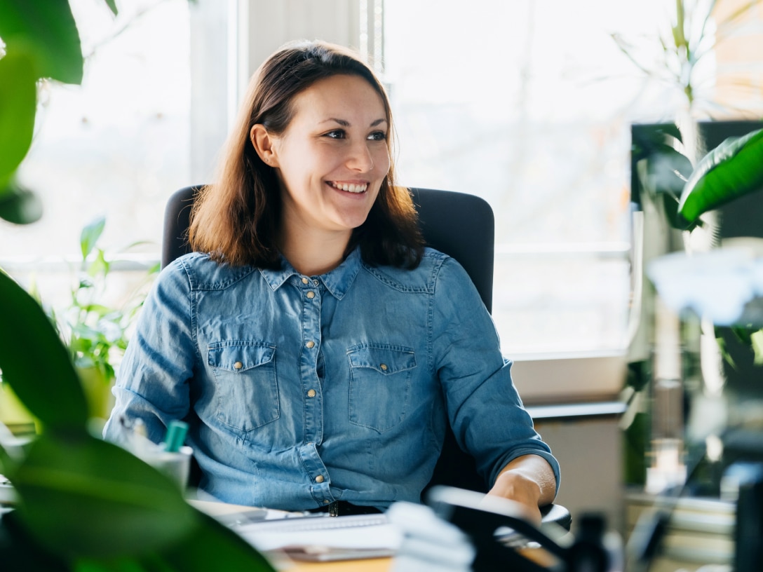 Woman in an office environment smiling.