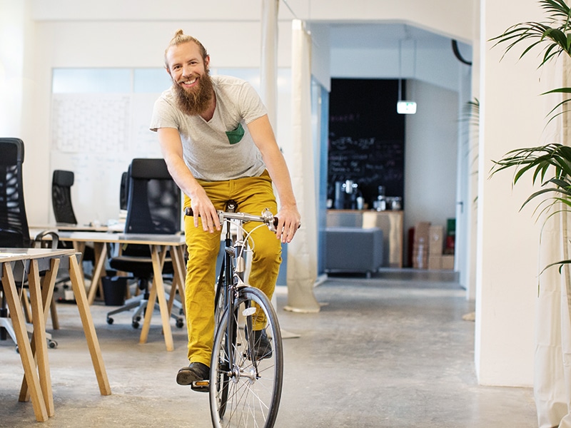 Mann auf Fahrrad im Büro