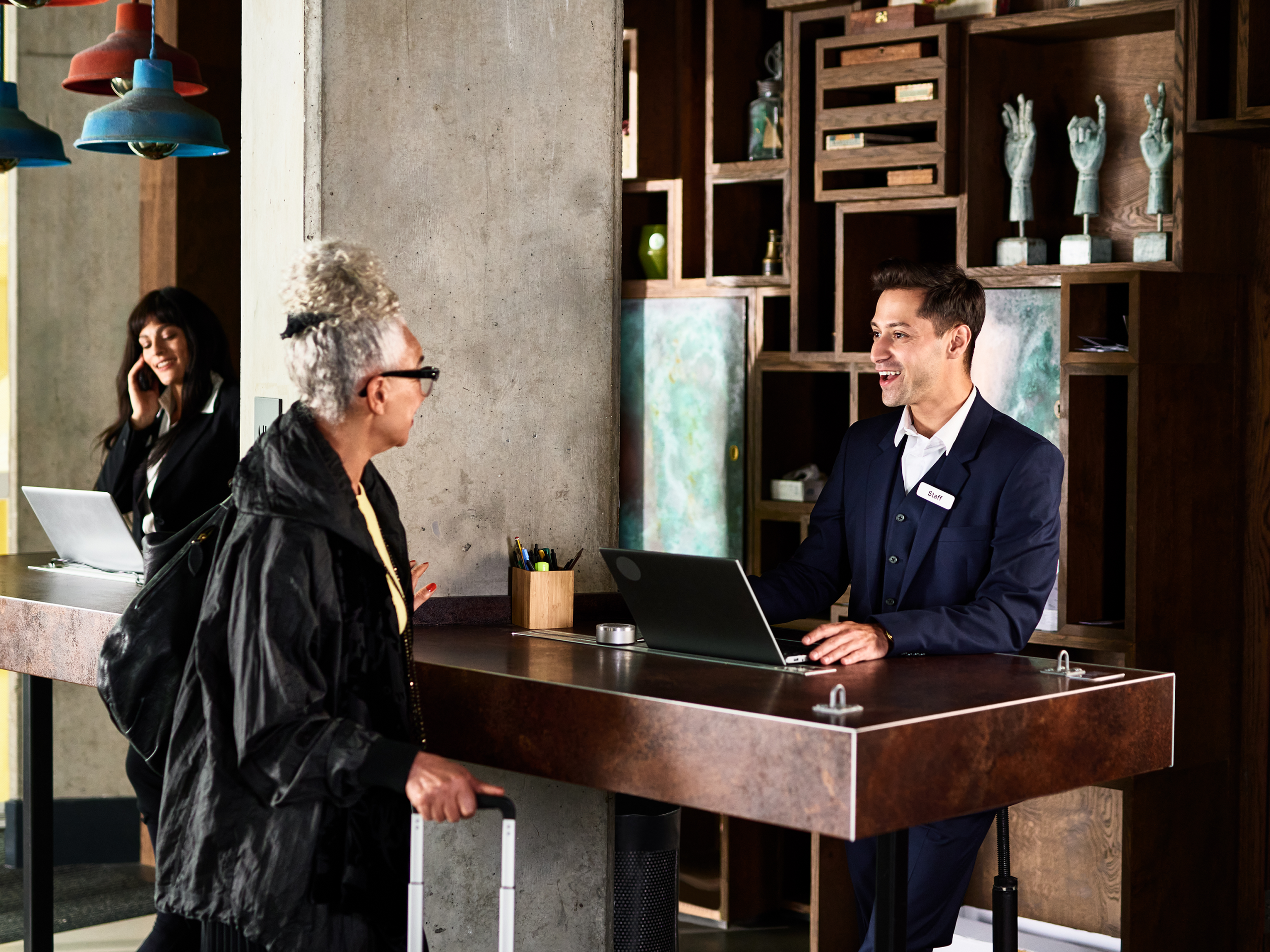 Cheerful male receptionist serving woman in hotel