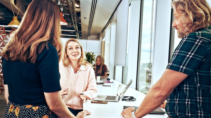 Marketingteam arbeitet in einem hellen Büro zusammen, um Lösungen für personalisierte Kundenerlebnisse zu entwickeln.