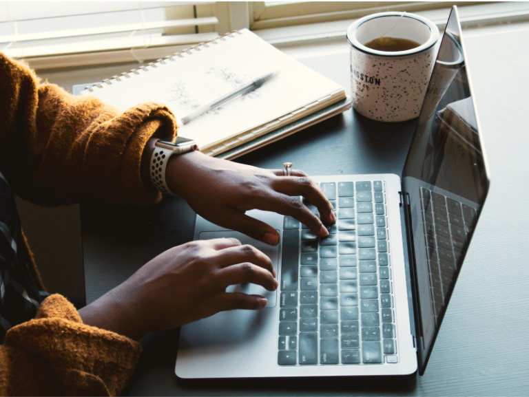 Woman writing on a Laptop