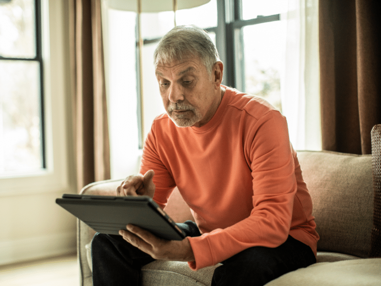Ein älterer Mann, der auf einem Tablet liest