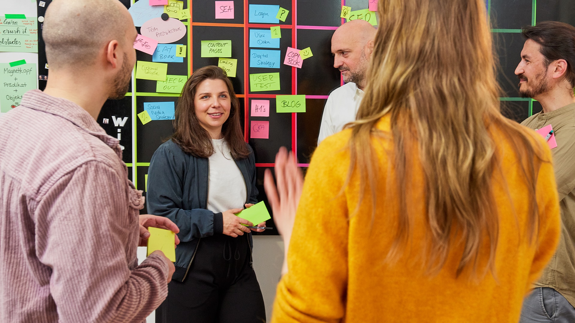 Besprechung mit mehreren Personen vor einem Board