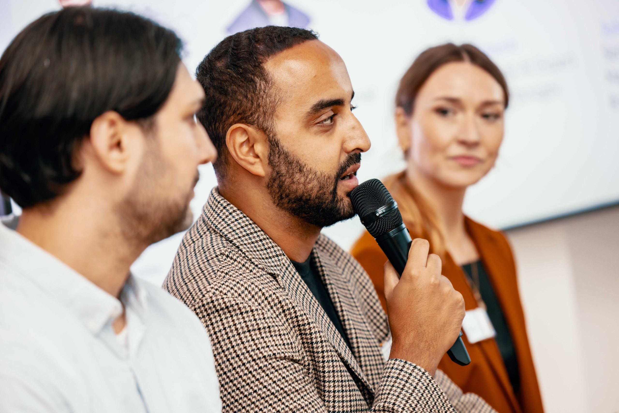 Ein Mann, der ein Mikrofon hält, spricht auf einem Meetup-Event.