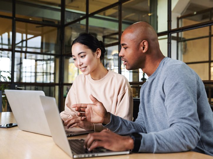 Men and woman are looking at laptop