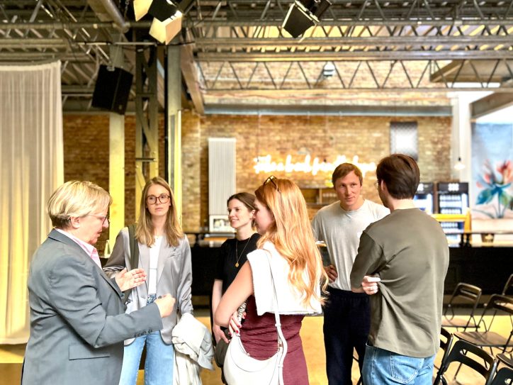 Eine Gruppe von Menschen unterhält sich in einem modernen Veranstaltungsraum während IBM Healthcare Meetup