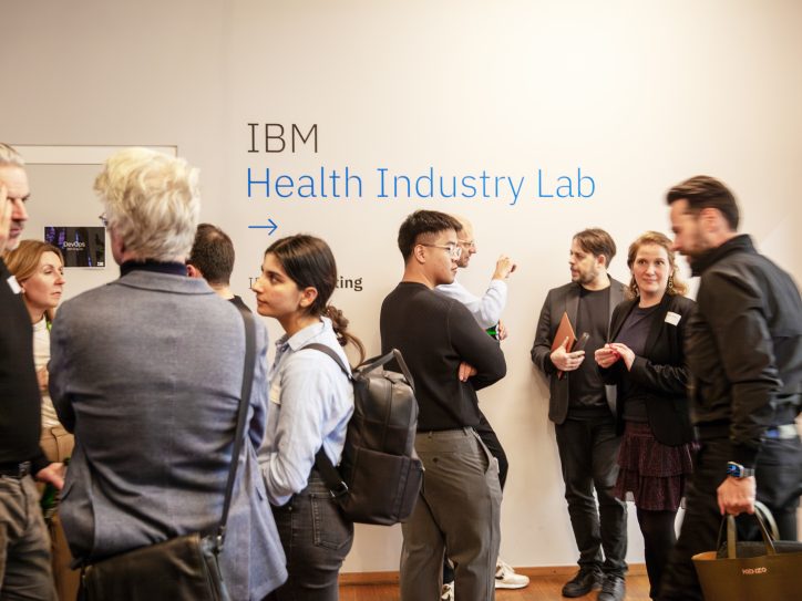 Eine Gruppe von Menschen versammelt sich im IBM Health Industry Lab für ein Networking-Event oder eine Präsentation.
