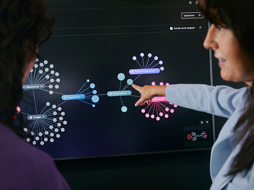 Two people are analyzing a data visualization on a screen.