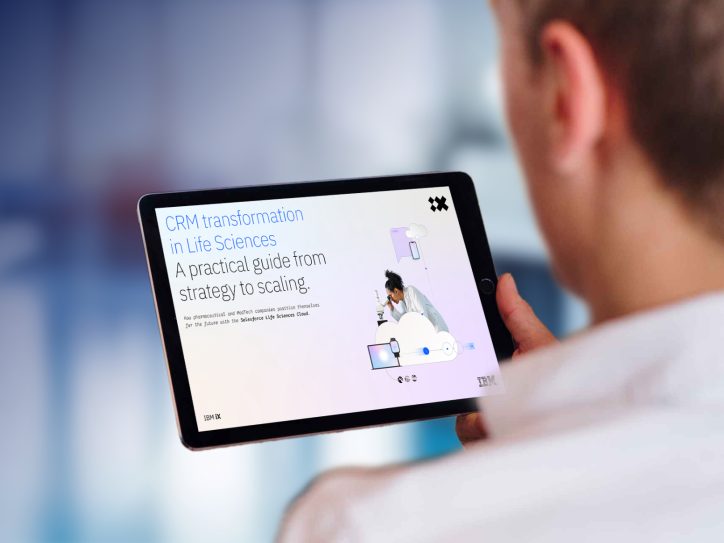 A person is holding a tablet showing a digital guide titled ‘CRM transformation in Life Sciences – A practical guide from strategy to scaling.’ The screen also displays an illustration of a scientist using a microscope, along with cloud and device icons.