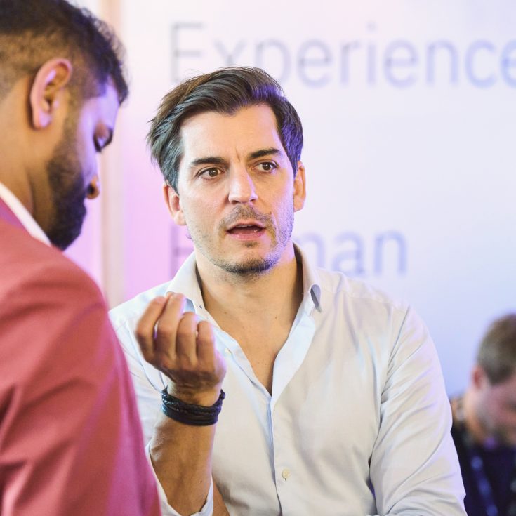 IBM iX and METRO collaboration on transforming customer experience globally. Two professionals engaged in a discussion, highlighting the focus on enhancing customer interactions.