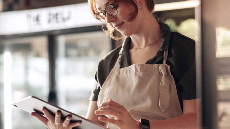 Mitarbeiter nutzt ein Tablet in einer modernen Einzelhandelsumgebung und zeigt die weltweite Transformation der Customer Experience durch IBM iX für METRO.