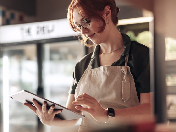 Mitarbeiter nutzt ein Tablet in einer modernen Einzelhandelsumgebung und zeigt die weltweite Transformation der Customer Experience durch IBM iX für METRO.