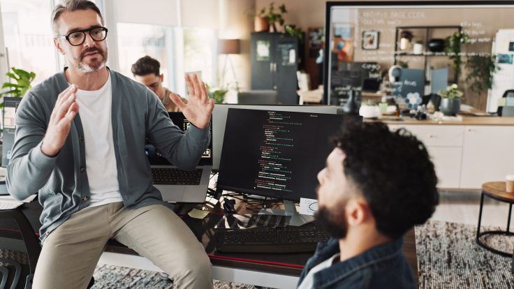 Team bespricht Strategien zur Marketing‑Personalisierung in einem modernen Büro mit Code auf einem Computerbildschirm.