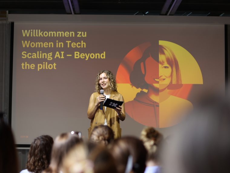 Vortrag bei einem Women in Tech Event über Scaling AI vor Publikum mit großer Präsentationsfolie im Hintergrund.