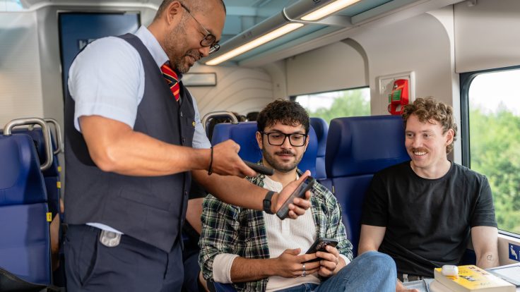 Zugbegleiter scannt digitales Ticket auf Smartphone in einem modernen Zug und zeigt nahtlose Omni-Channel Customer Experience der Niederländischen Eisenbahn.